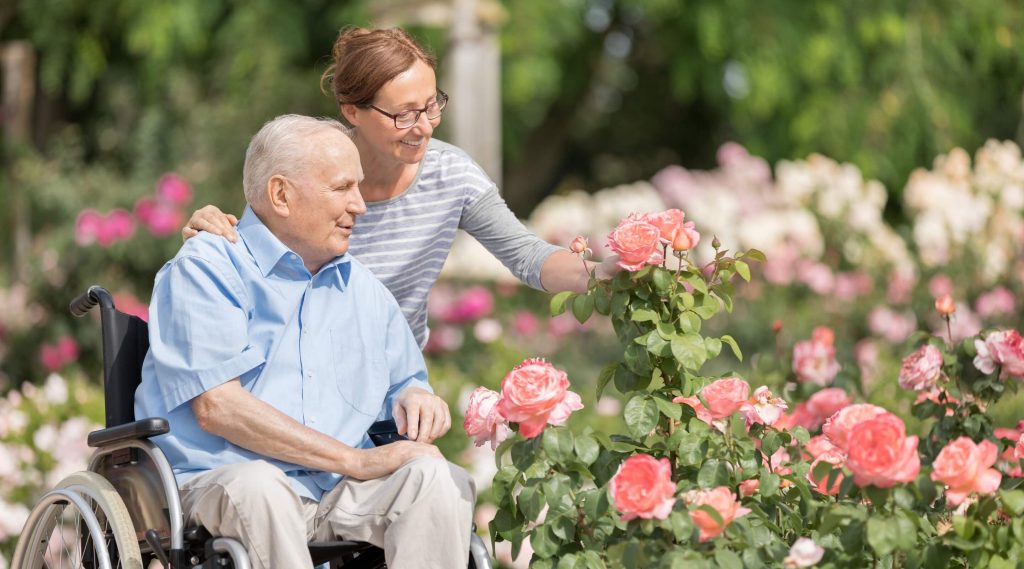 Man in wheelchair with carer after a social care journey