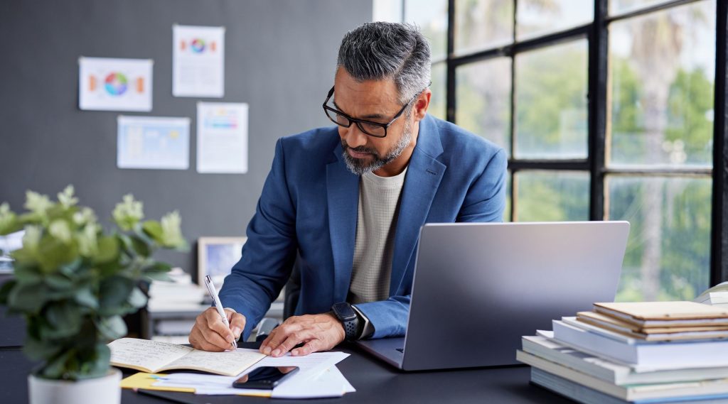 Business man sat at desk looking at paperwork for the profit rule