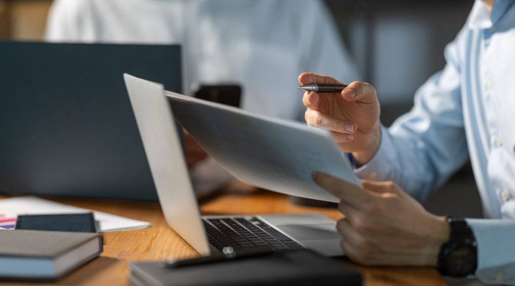 Two men reviewing Material Adverse Change with laptops
