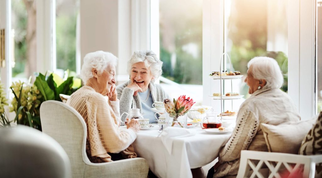 Ladies in a care home discussing fee top ups