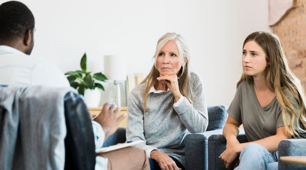 Woman and daughter sat on sofa speaking about probate disputes